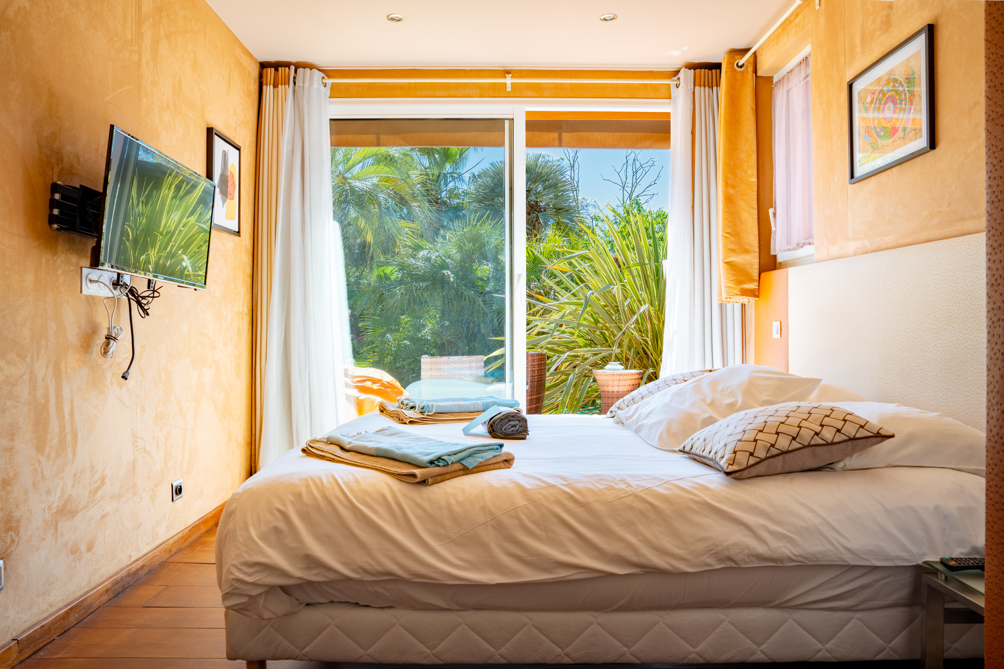 Chambre 5 lumineuse mur orange avec vue terrasse jardin